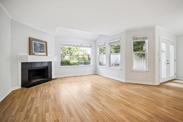 unfurnished living room with light wood finished floors, a healthy amount of sunlight, and ornamental molding