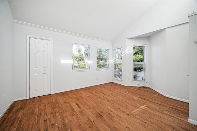 unfurnished room with baseboards, hardwood / wood-style floors, and vaulted ceiling