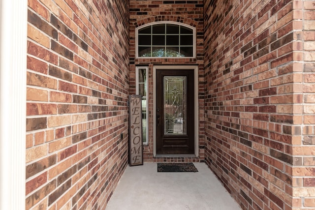 doorway to property with brick siding