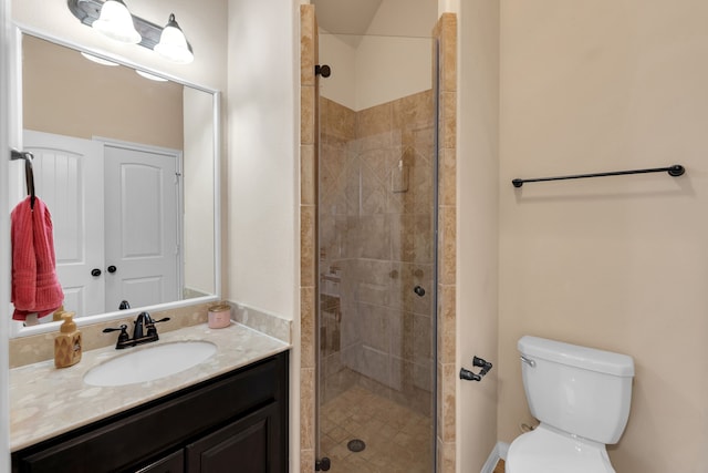 bathroom with toilet, a stall shower, and vanity