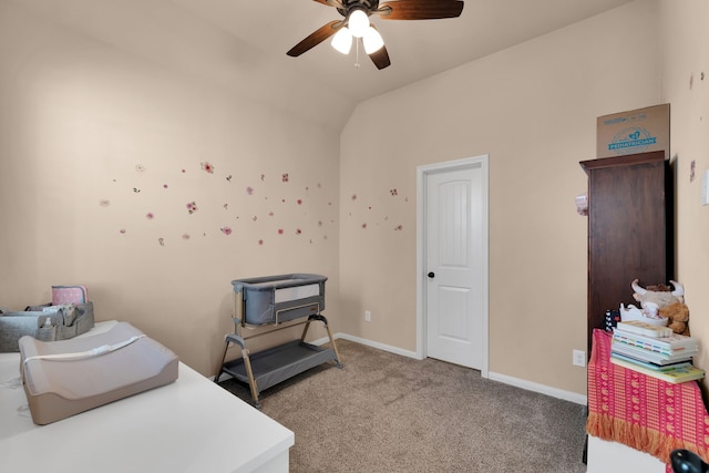 carpeted office space with lofted ceiling, a ceiling fan, and baseboards