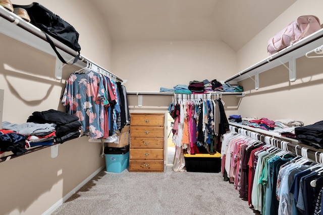 walk in closet featuring lofted ceiling and carpet