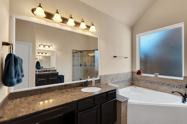 bathroom featuring a shower stall, a garden tub, vanity, and lofted ceiling