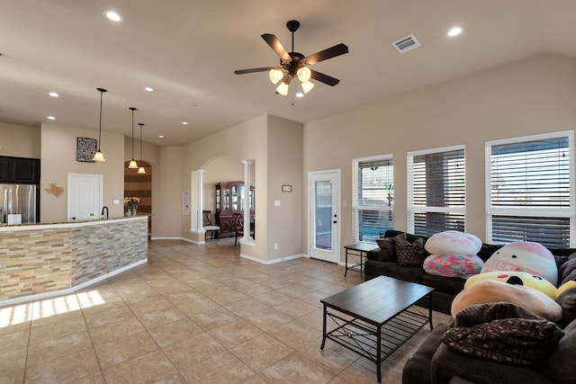 living area with visible vents, light tile patterned floors, recessed lighting, arched walkways, and a ceiling fan