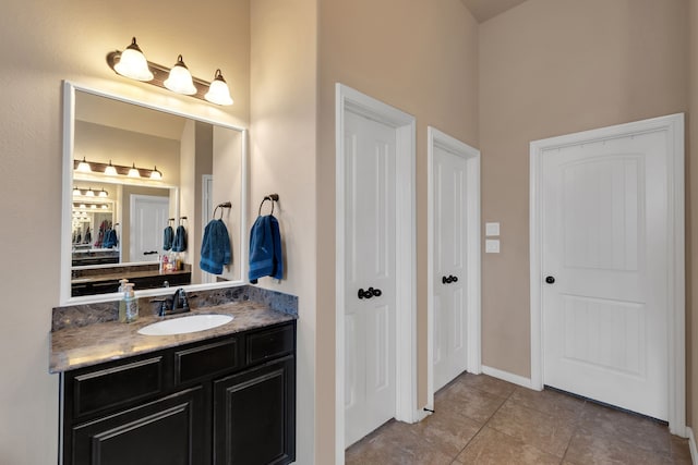 bathroom with tile patterned floors, baseboards, and vanity