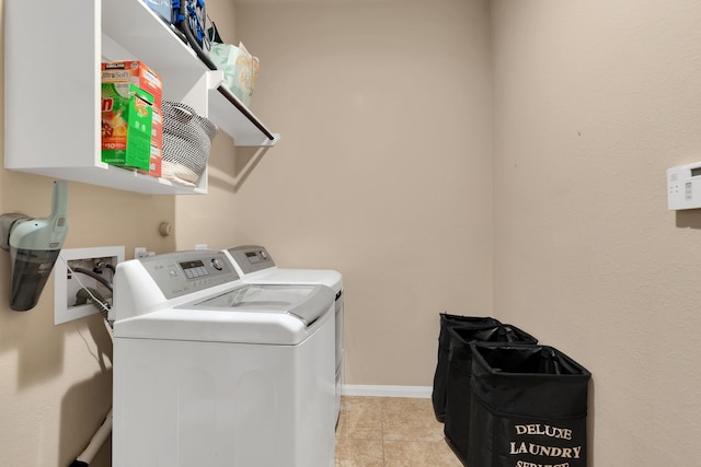 laundry area featuring laundry area, light tile patterned floors, washing machine and dryer, and baseboards