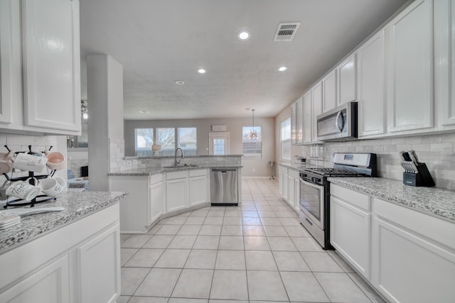 kitchen with light tile patterned floors, white cabinetry, appliances with stainless steel finishes, and a sink