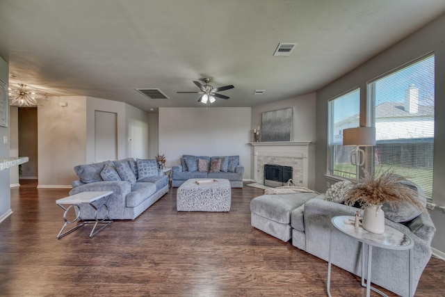 living area featuring visible vents, a fireplace with flush hearth, dark wood-type flooring, a ceiling fan, and baseboards