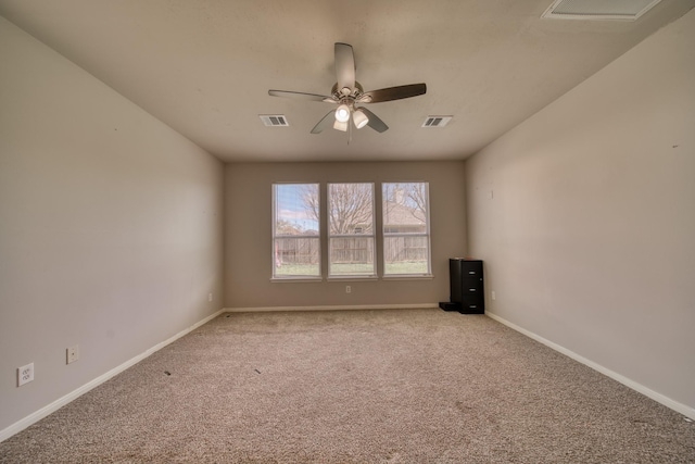 carpeted empty room featuring visible vents, baseboards, and ceiling fan