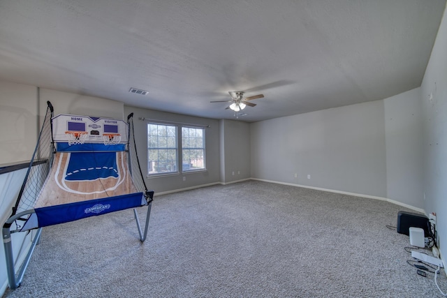 playroom with visible vents, a textured ceiling, carpet flooring, baseboards, and ceiling fan