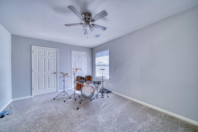 interior space featuring visible vents, carpet floors, baseboards, and a ceiling fan