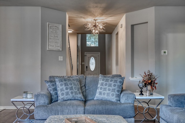 living room featuring baseboards, an inviting chandelier, and wood finished floors