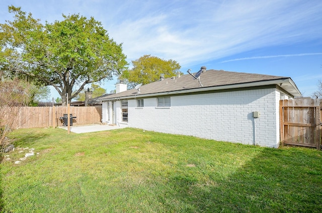 5343 Linda Ln, Katy, TX 77493 - back of property featuring a lawn, a patio, a fenced backyard, brick siding, and a chimney