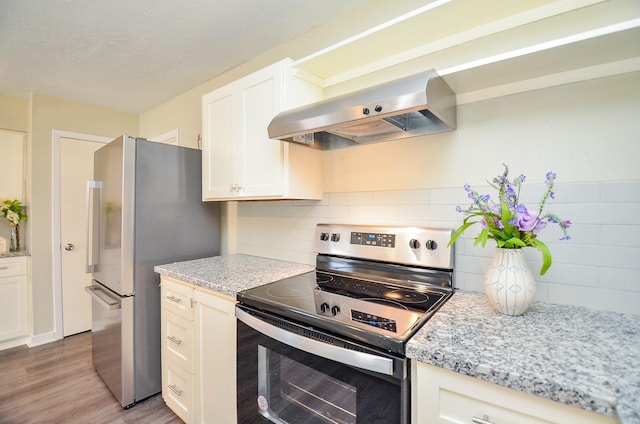 5343 Linda Ln, Katy, TX 77493 - kitchen with white cabinetry, appliances with stainless steel finishes, wall chimney exhaust hood, light wood finished floors, and decorative backsplash