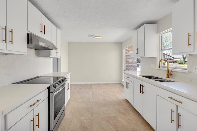 kitchen with stainless steel electric range oven, light countertops, under cabinet range hood, and a sink