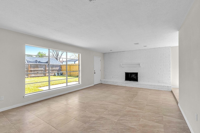 unfurnished living room with a fireplace, a textured ceiling, and baseboards