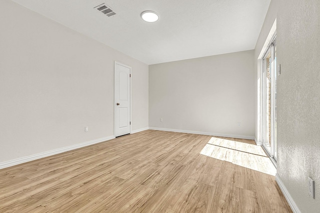 unfurnished room with visible vents, baseboards, and light wood finished floors