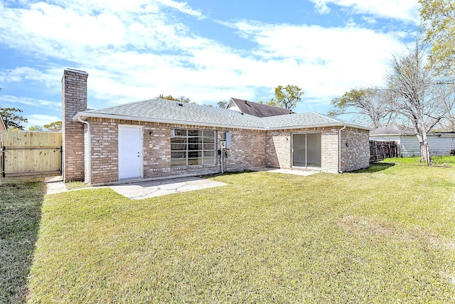 back of property with a lawn, a chimney, a patio, and fence