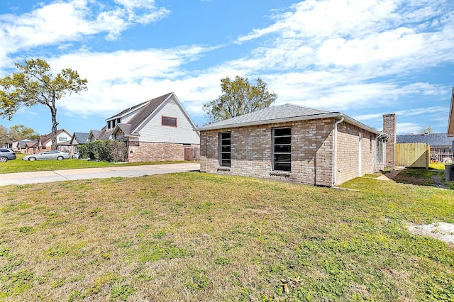 view of front of property featuring brick siding, a front yard, and fence