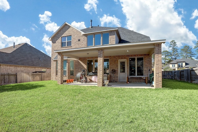 back of property featuring a patio, a yard, a fenced backyard, and brick siding