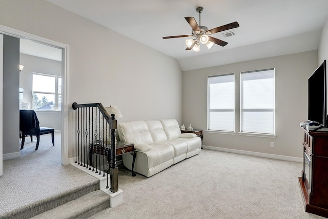 carpeted living room with baseboards, lofted ceiling, visible vents, and a ceiling fan