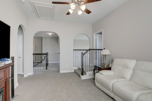 interior space featuring baseboards, carpet, attic access, an upstairs landing, and a ceiling fan