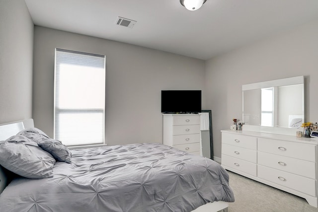 bedroom featuring visible vents and light colored carpet