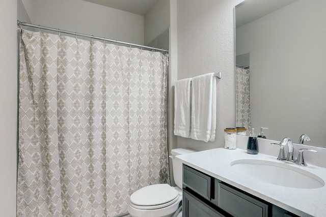 full bathroom featuring a shower with shower curtain, toilet, and vanity