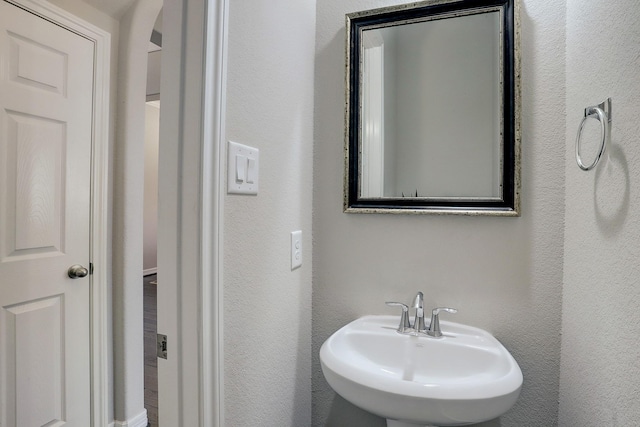 bathroom featuring a sink and a textured wall