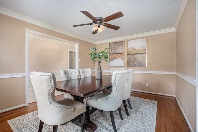 dining area with baseboards, ornamental molding, a ceiling fan, and hardwood / wood-style flooring