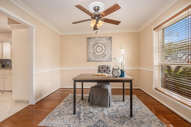 office featuring baseboards, crown molding, a ceiling fan, and wood finished floors