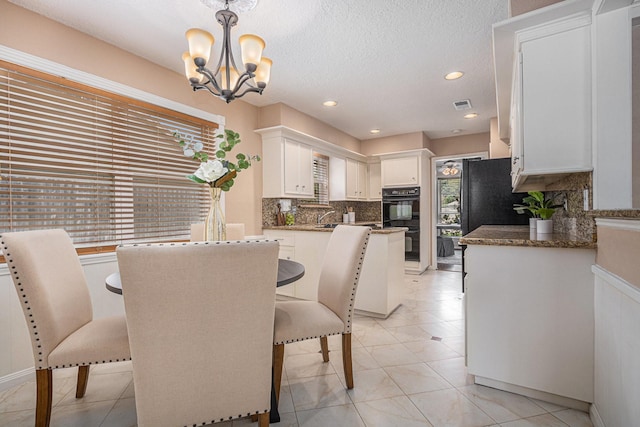 dining area with visible vents, light tile patterned flooring, recessed lighting, a textured ceiling, and a chandelier