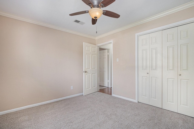 unfurnished bedroom with carpet flooring, baseboards, visible vents, and ornamental molding