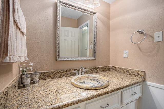 bathroom with vanity and a textured wall