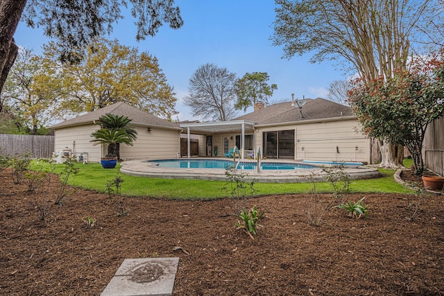 back of property with a fenced in pool, a yard, and a fenced backyard