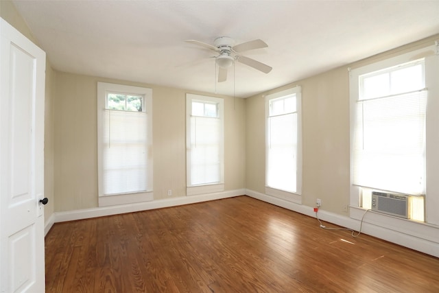 spare room featuring cooling unit, baseboards, a ceiling fan, and wood finished floors