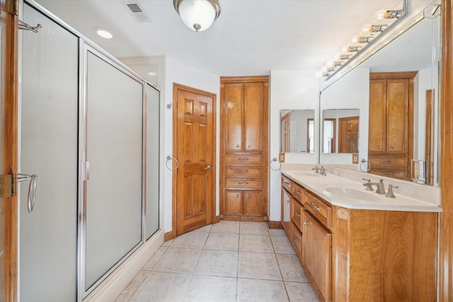 full bath featuring tile patterned floors, visible vents, a shower stall, and a sink