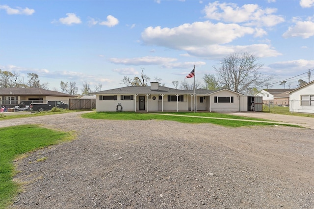 single story home featuring driveway, a chimney, and fence