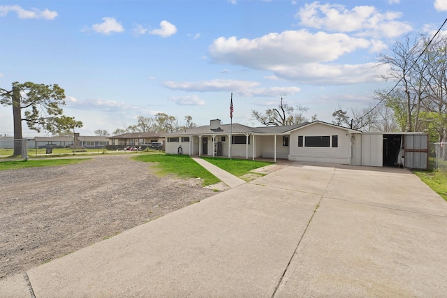 ranch-style house featuring concrete driveway and a front yard