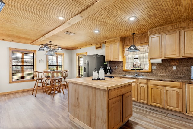 kitchen with visible vents, wooden counters, a sink, decorative backsplash, and stainless steel fridge