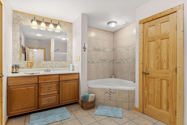 full bath with tile patterned flooring, visible vents, tile walls, tiled tub, and vanity