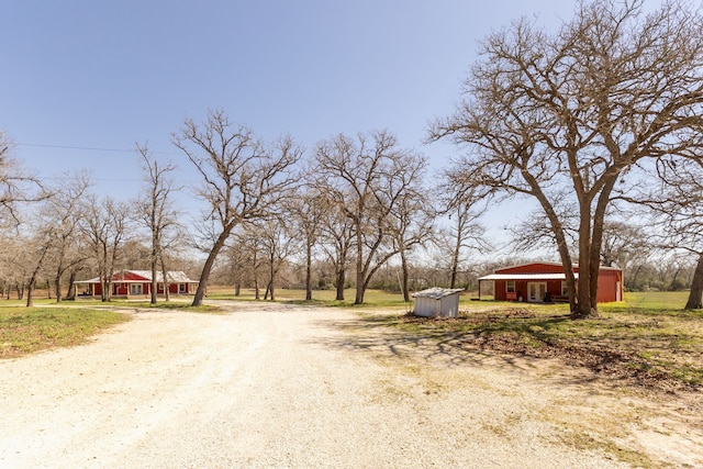 view of street featuring an outbuilding and dirt driveway