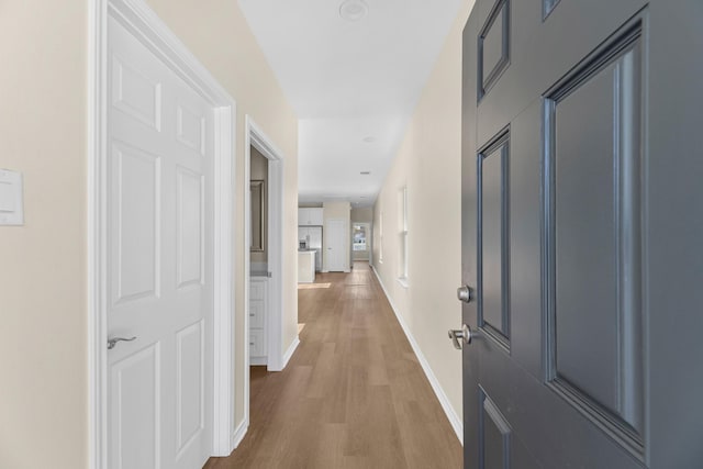 hallway featuring wood finished floors and baseboards