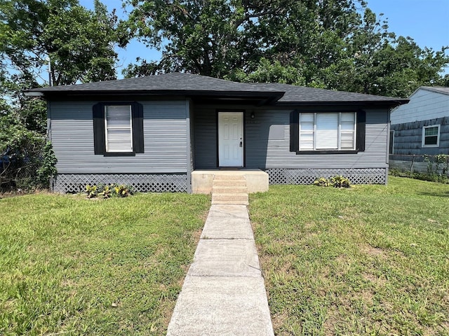 view of front of property with roof with shingles, a front lawn, and fence