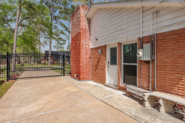 view of patio / terrace featuring concrete driveway and a gate