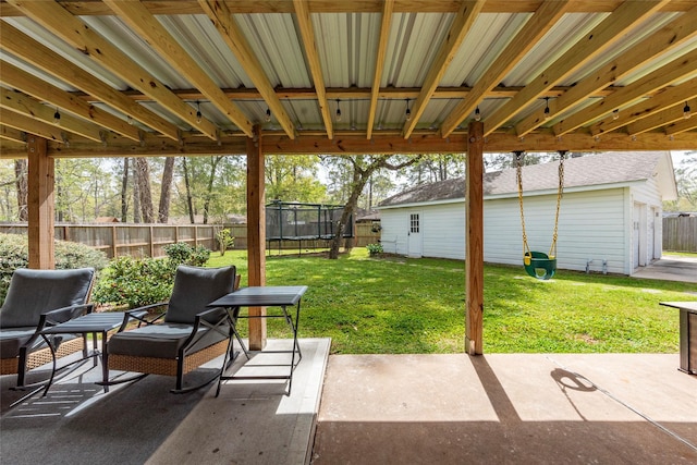 view of patio / terrace featuring a trampoline and fence