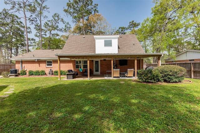 rear view of property featuring central AC unit, fence, and a lawn