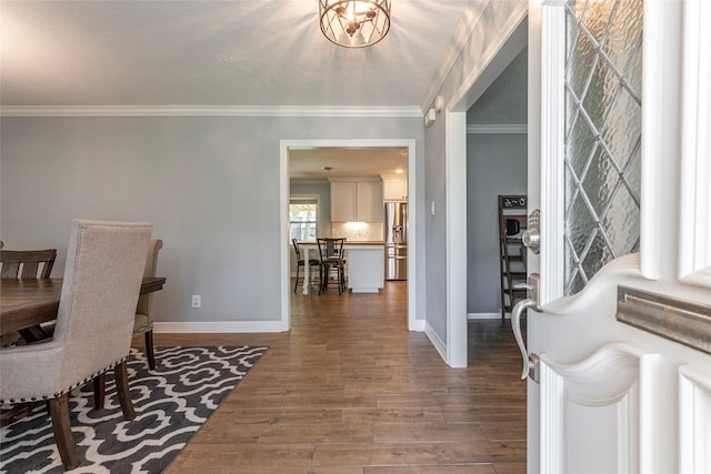 entryway with baseboards, wood finished floors, and ornamental molding