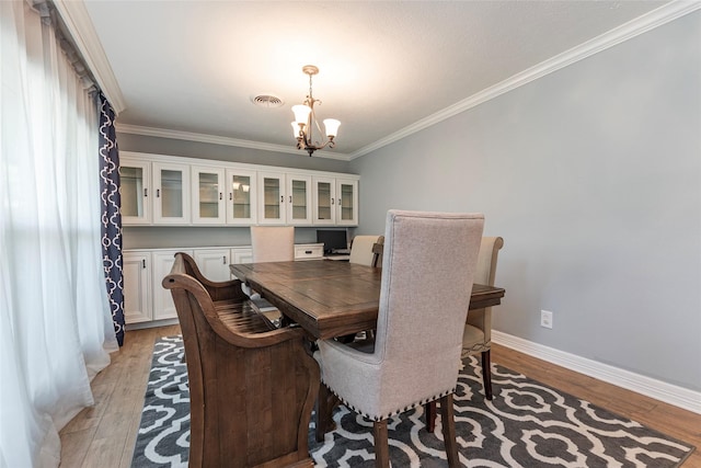 dining area with light wood-type flooring, baseboards, a notable chandelier, and visible vents