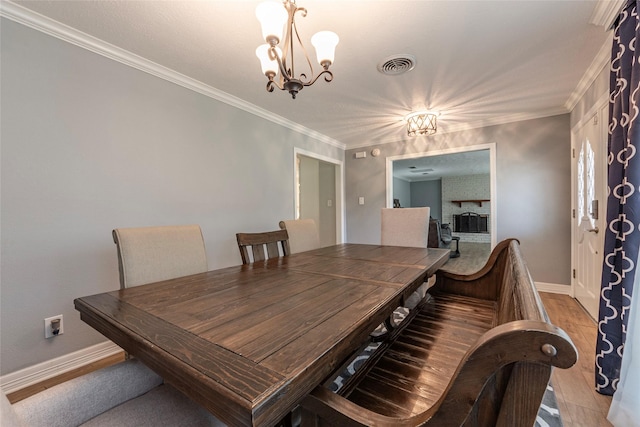 dining area featuring a chandelier, visible vents, baseboards, and wood finished floors